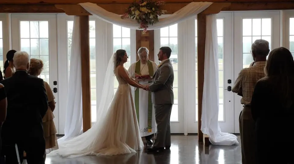 a bride and groom take one another's hands during wedding ceremony
