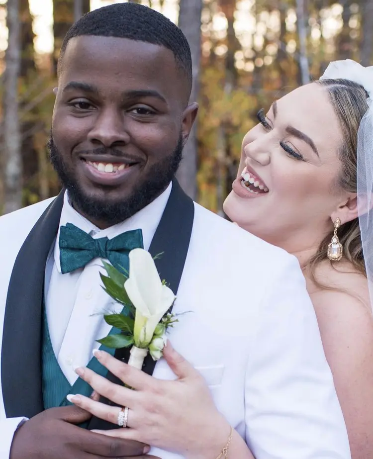 bride and groom smiling in wooded setting