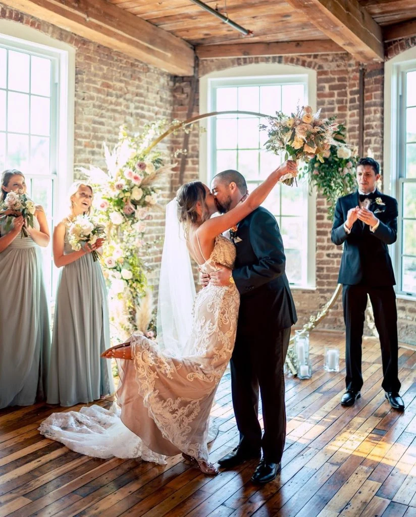 bridge and groom kiss during wedding ceremony